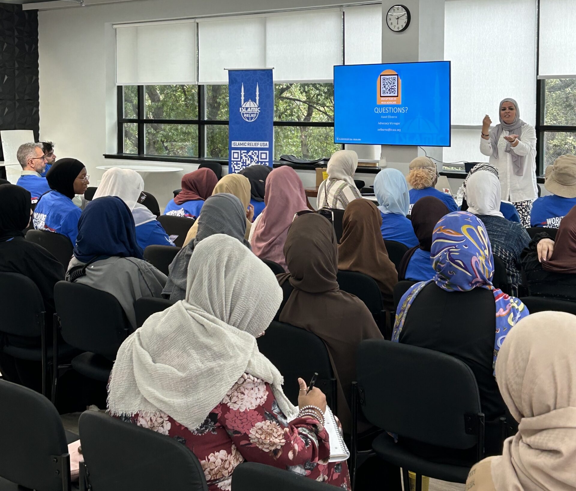 A woman is seen speaking in from of an audience