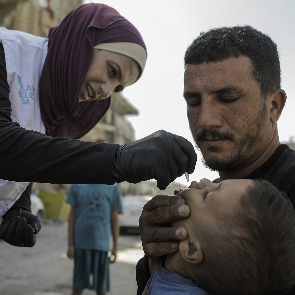 A woman delivering medicine to a young boy.